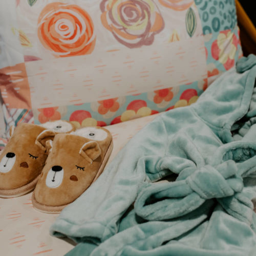 Picture of a bed with slippers and a dressing gown