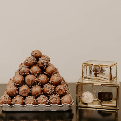 Picture of a pyramid of chocolate truffles with two containers of chocolate on the side
