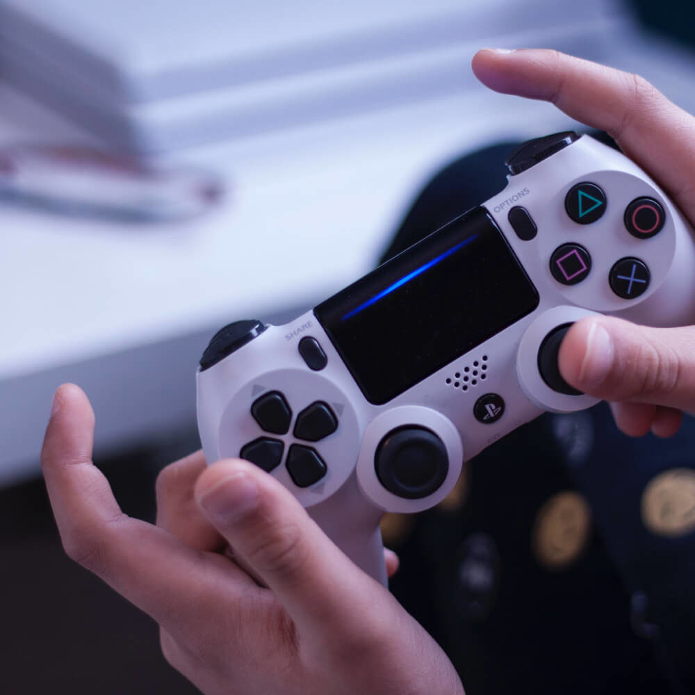 Person holding white playstation controller