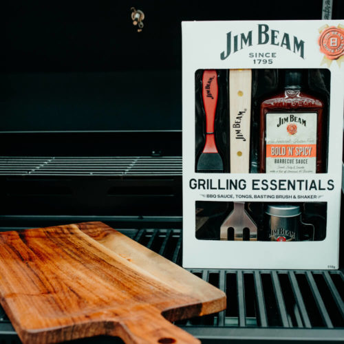 Picture of a BBQ with a chopping board and a jim beam grilling essentials set