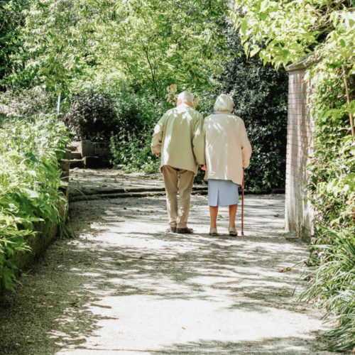 Picture of elderly couple walking down pathway