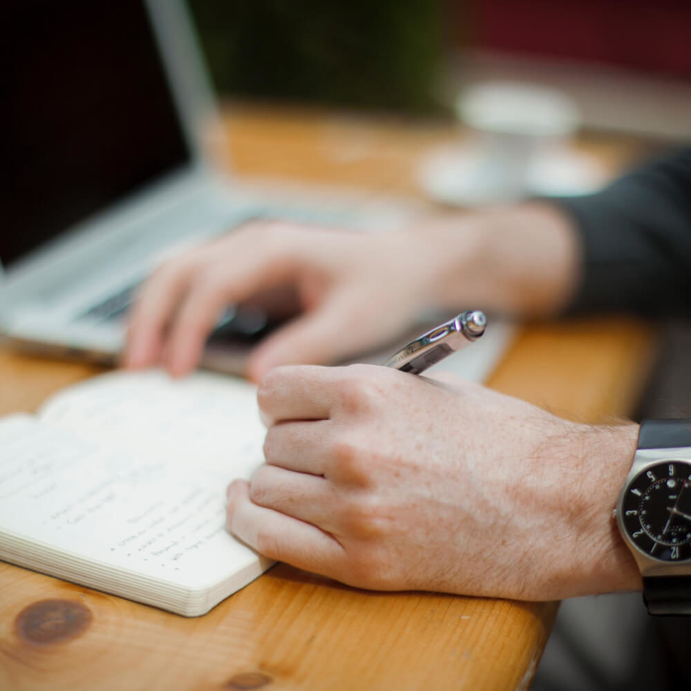 Picture of male hand writing in notebook